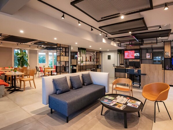 A modern lounge area with a sofa, coffee table, and seating arrangements. - Ibis Roquebrune Cap Martin Menton (Roquebrune-Cap-Martin)