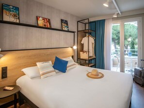 A hotel room with a large bed, a bedside table, a wardrobe, and a view of the outdoors. - Ibis Roquebrune Cap Martin Menton (Roquebrune-Cap-Martin)