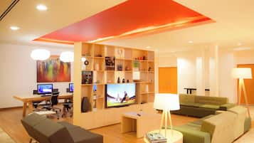 A modern living room with a TV, sofas, a coffee table, and a bookshelf.