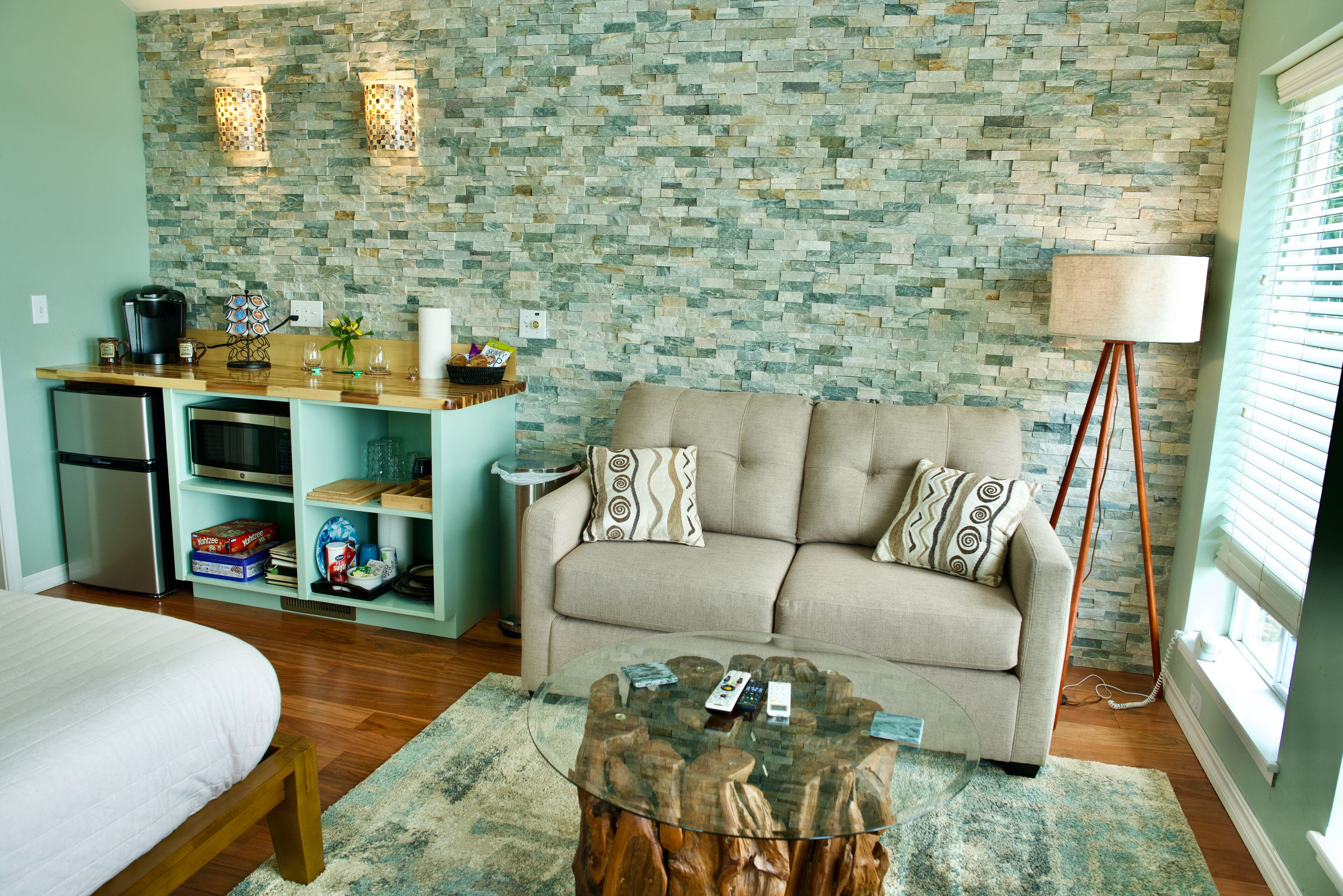 A compact living space with a kitchenette, a sofa, and a coffee table.
