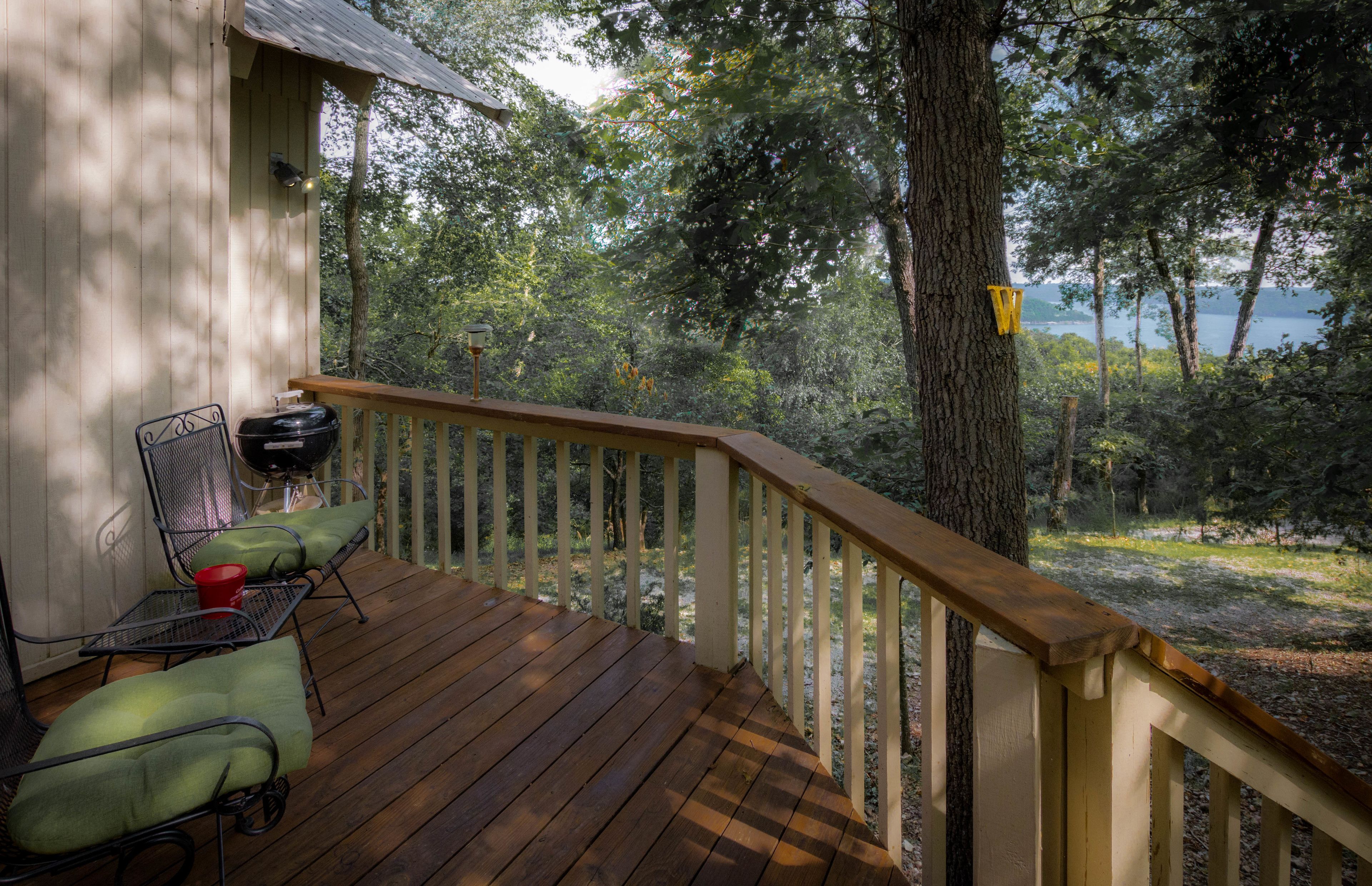 Una terraza de madera con mobiliario exterior y vistas a un lago.