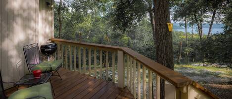 Una terraza de madera con mobiliario exterior y vistas a un lago.