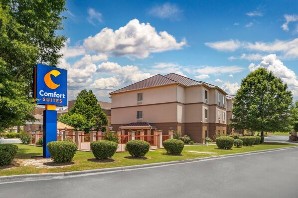 A Comfort Suites hotel with a large sign, a well-maintained lawn, and a clear sky. - Comfort Suites Montgomery East Monticello Dr. (Montgomery)