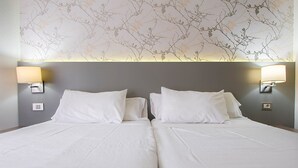 A double bed with white linens and two wall-mounted lamps on either side. - Apartamentos HG Tenerife Sur (Arona)