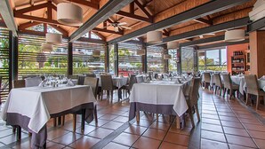 A spacious outdoor dining area with multiple tables and chairs, large hanging lights, and a wooden ceiling structure. - Apartamentos HG Tenerife Sur (Arona)
