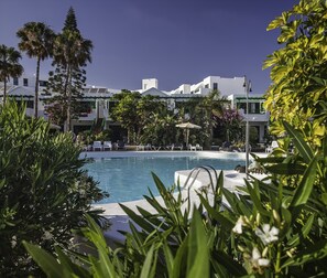 A pool area with lounge chairs and palm trees. - Apartamentos HG Lomo Blanco (Tías)