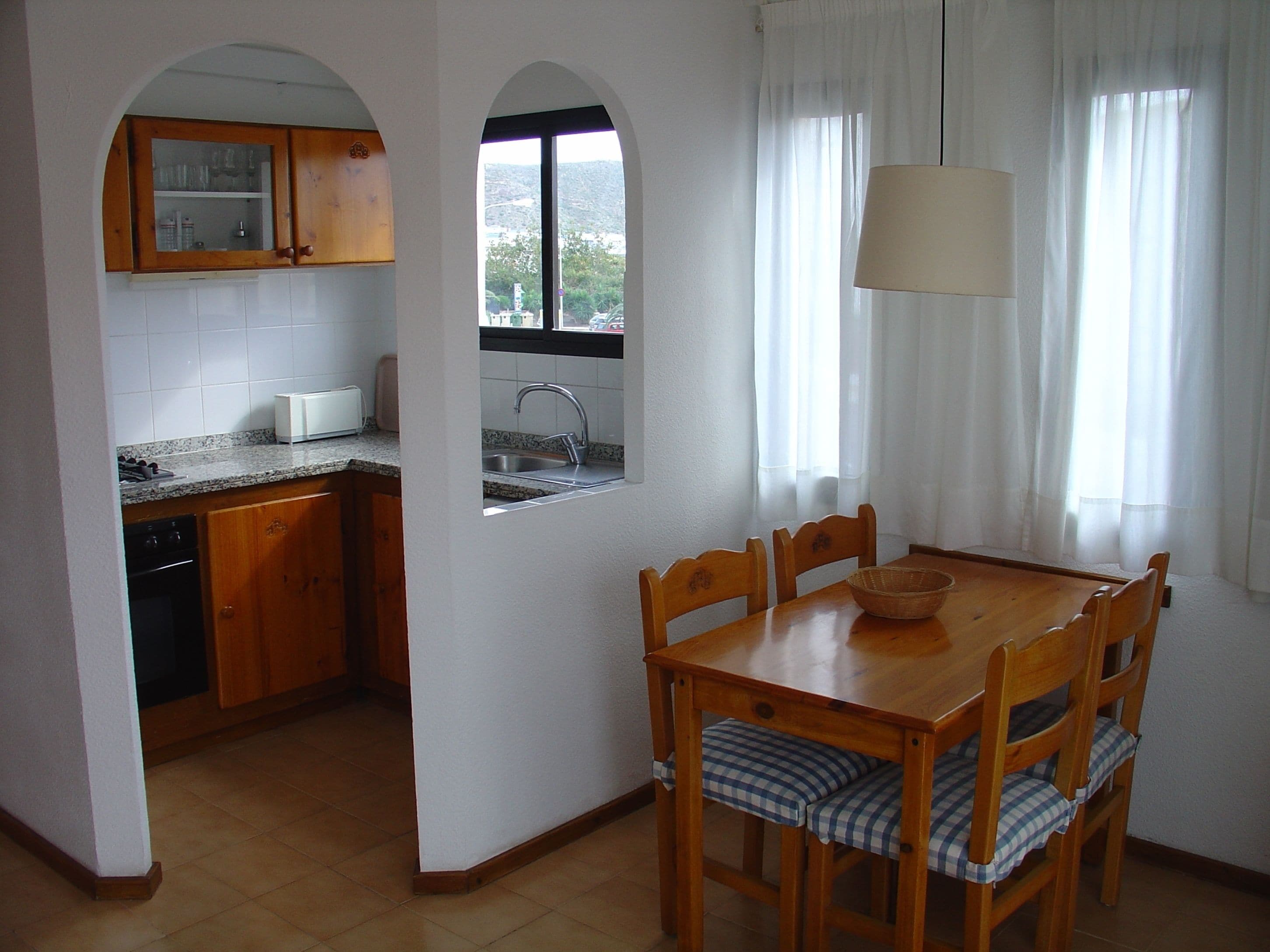 A kitchen with wooden cabinets, a built-in oven, and a window with a view.