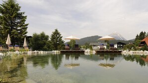 Un paisaje tranquilo junto al lago, con aguas transparentes, rodeado de árboles y una montaña al fondo.