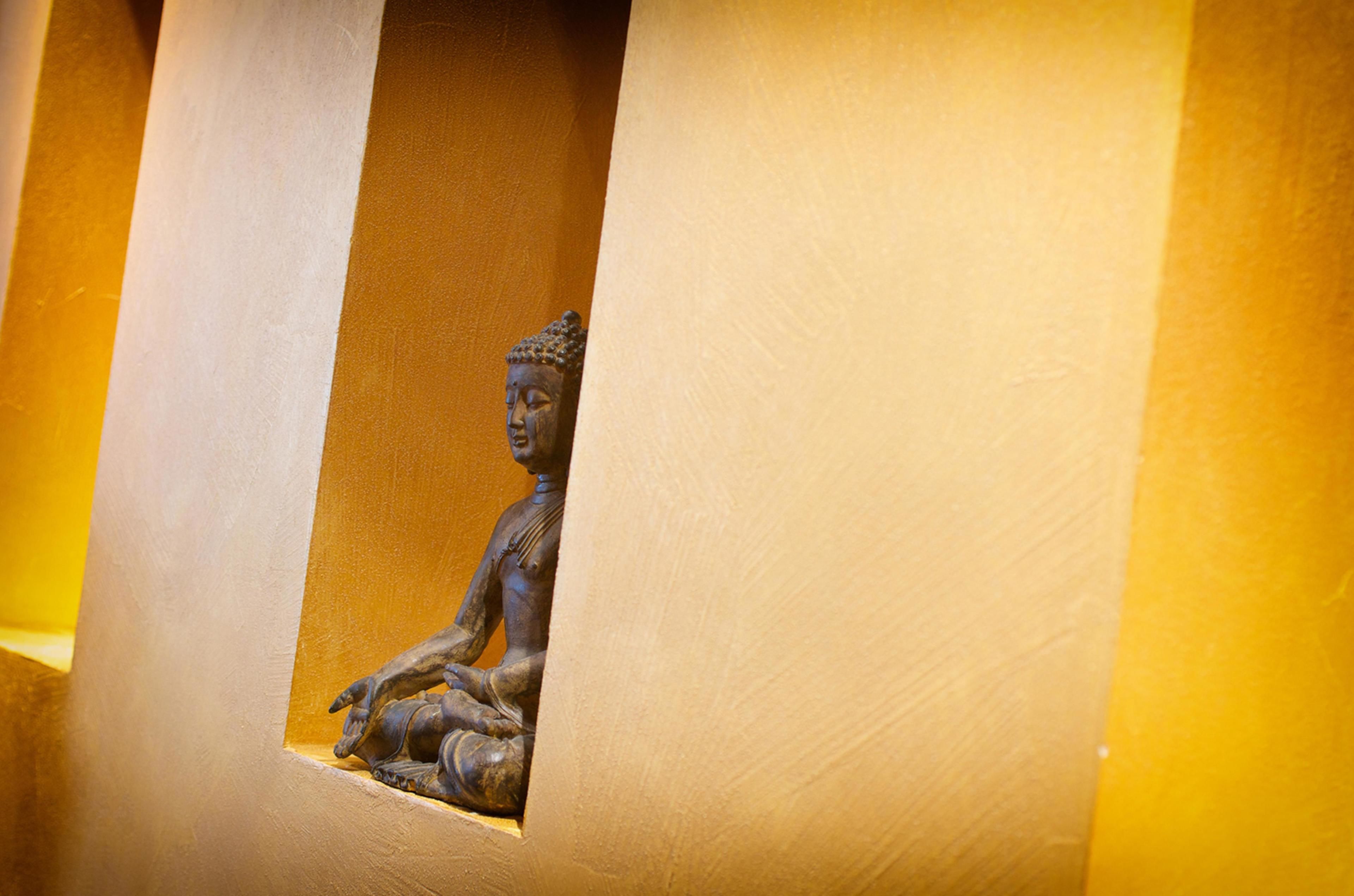 A statue of a seated figure in a niche.
