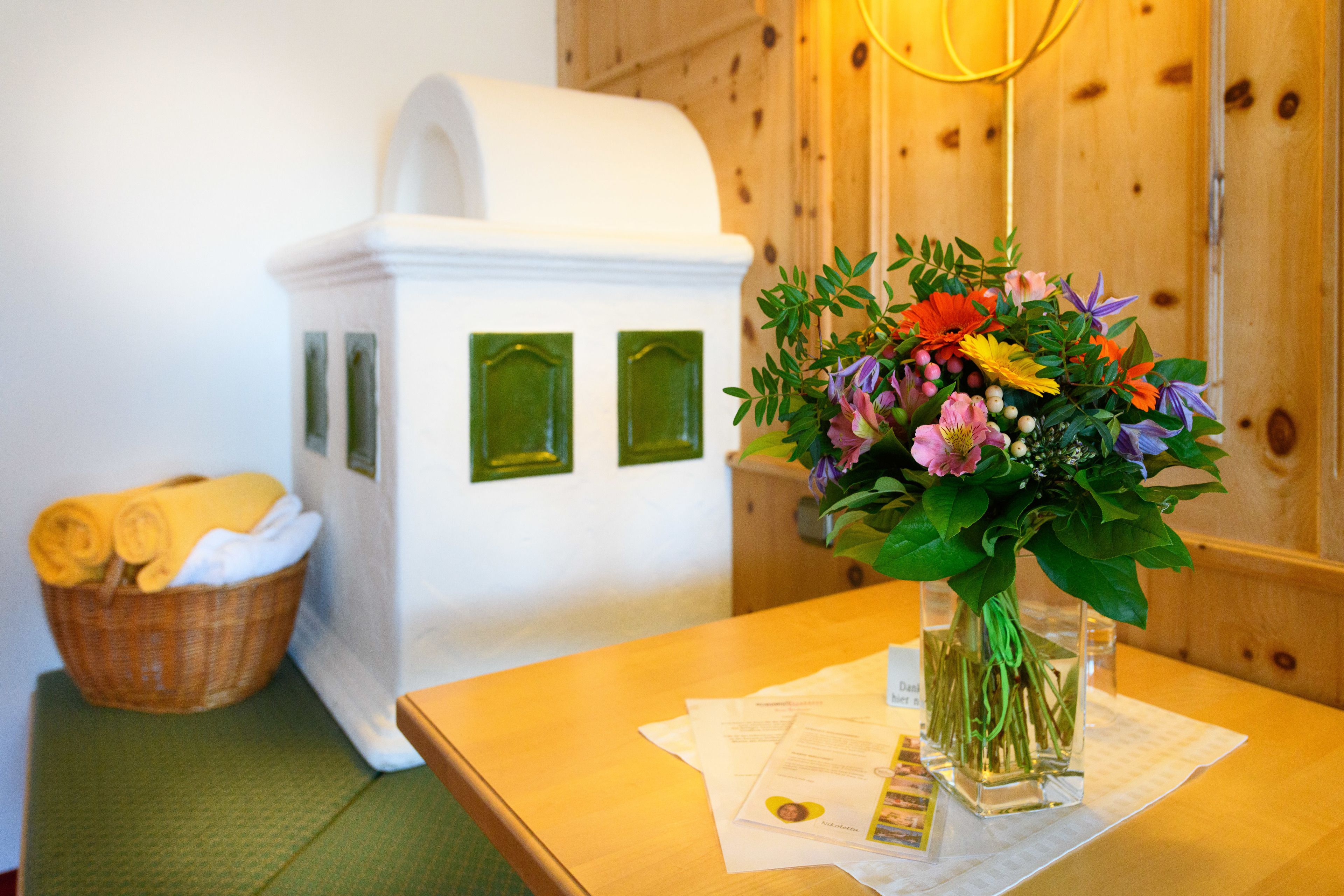 Een kamer met een houten tafel, een witte kast en een bloemenvaas.