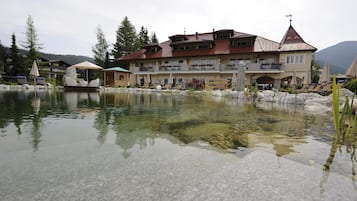 Guests can enjoy a serene atmosphere with a pond and lounge chairs on the grounds.