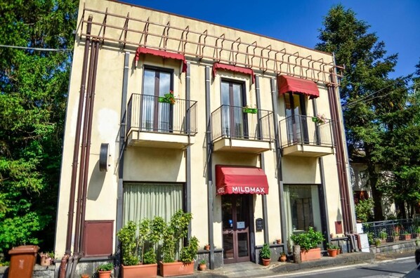 A building with a red awning labeled "MILOMAX" and balconies with railings. - Hotel Milomax (Milo)