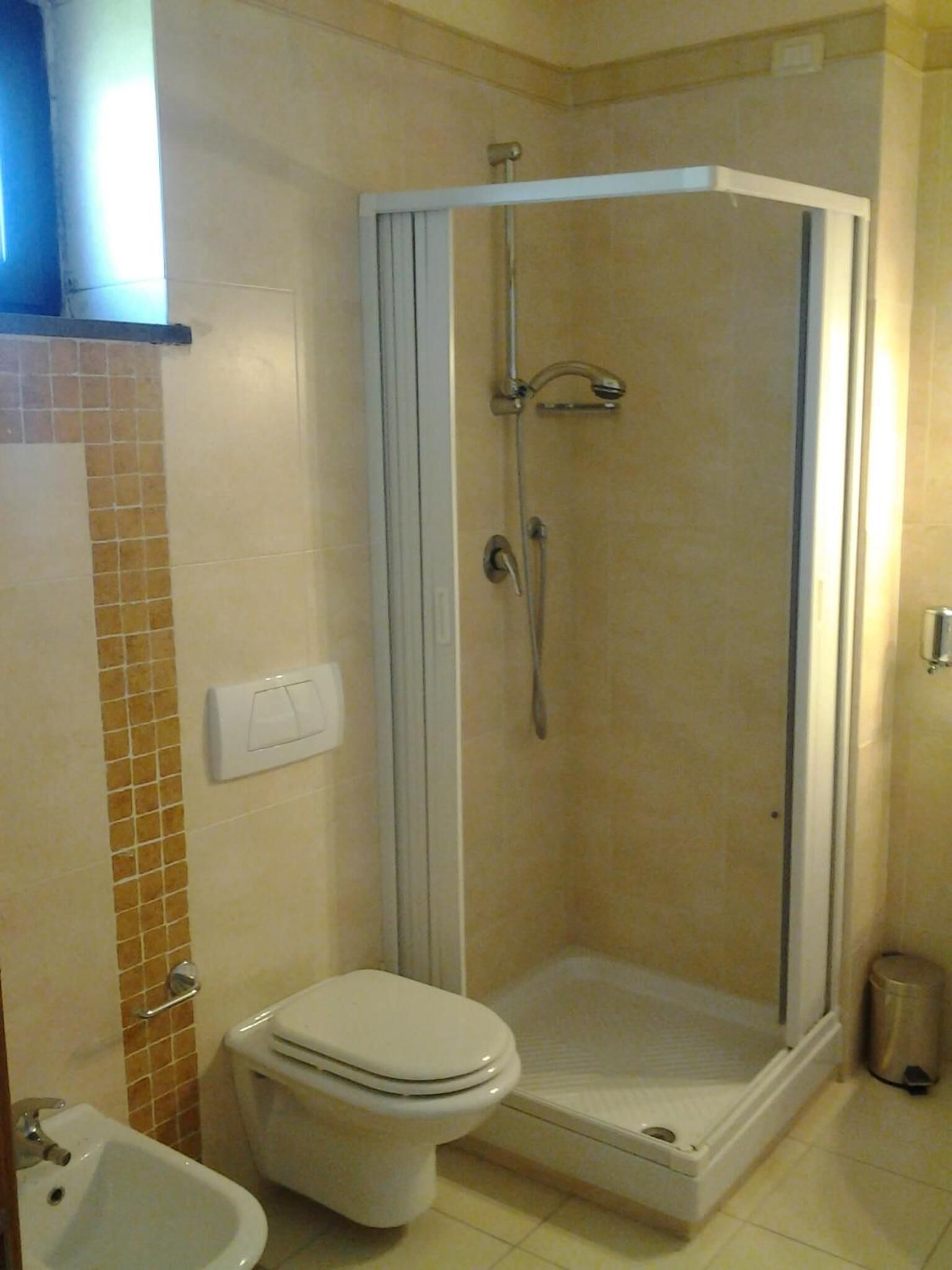 Un baño con ducha, inodoro y lavabo.