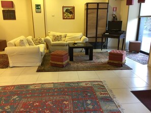 Un salon avec deux canapés, une table basse et un tapis à motifs.