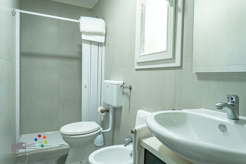A bathroom with a toilet, bidet, and sink.