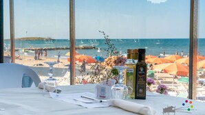 A table set for dining with a view of the beach and ocean.