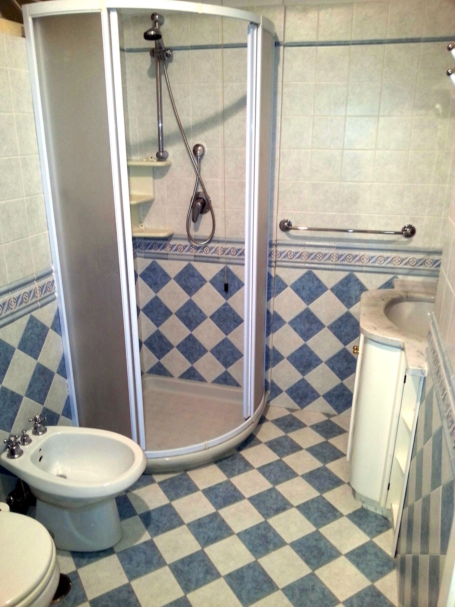 Un baño con cabina de ducha, un bidé y un lavabo.