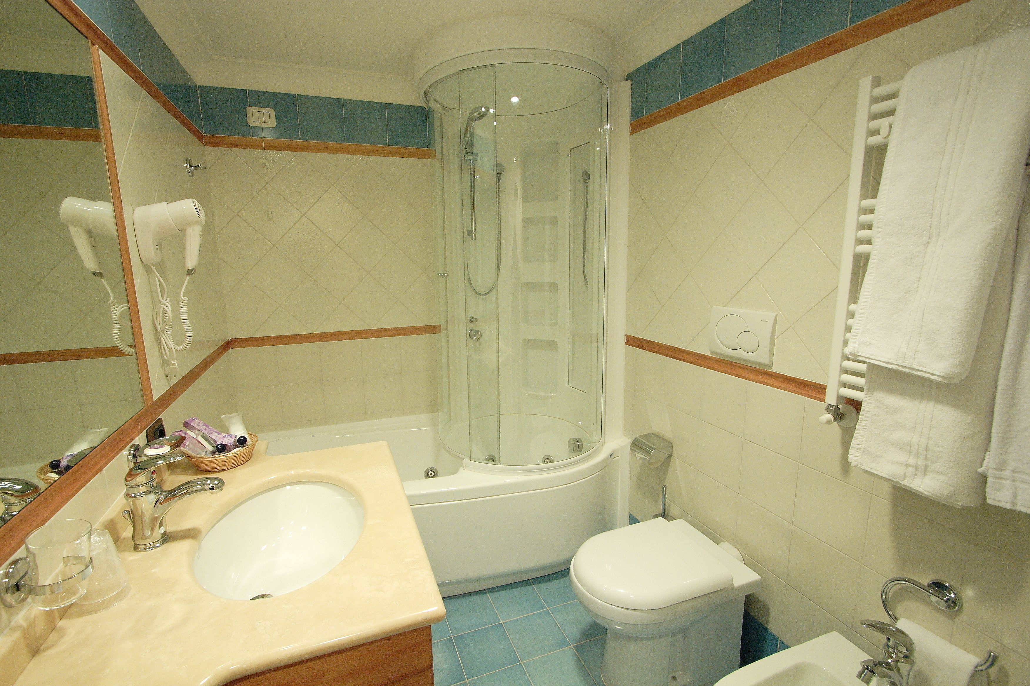 A bathroom with a sink, toilet, and shower.