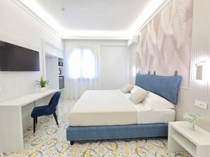 Une chambre d’hôtel moderne équipée d’un lit, d’un bureau, d’une chaise, d’une télévision et d’une fenêtre avec des rideaux.