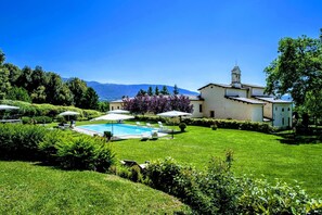 Una piscina techada, una piscina al aire libre de temporada, sombrillas
