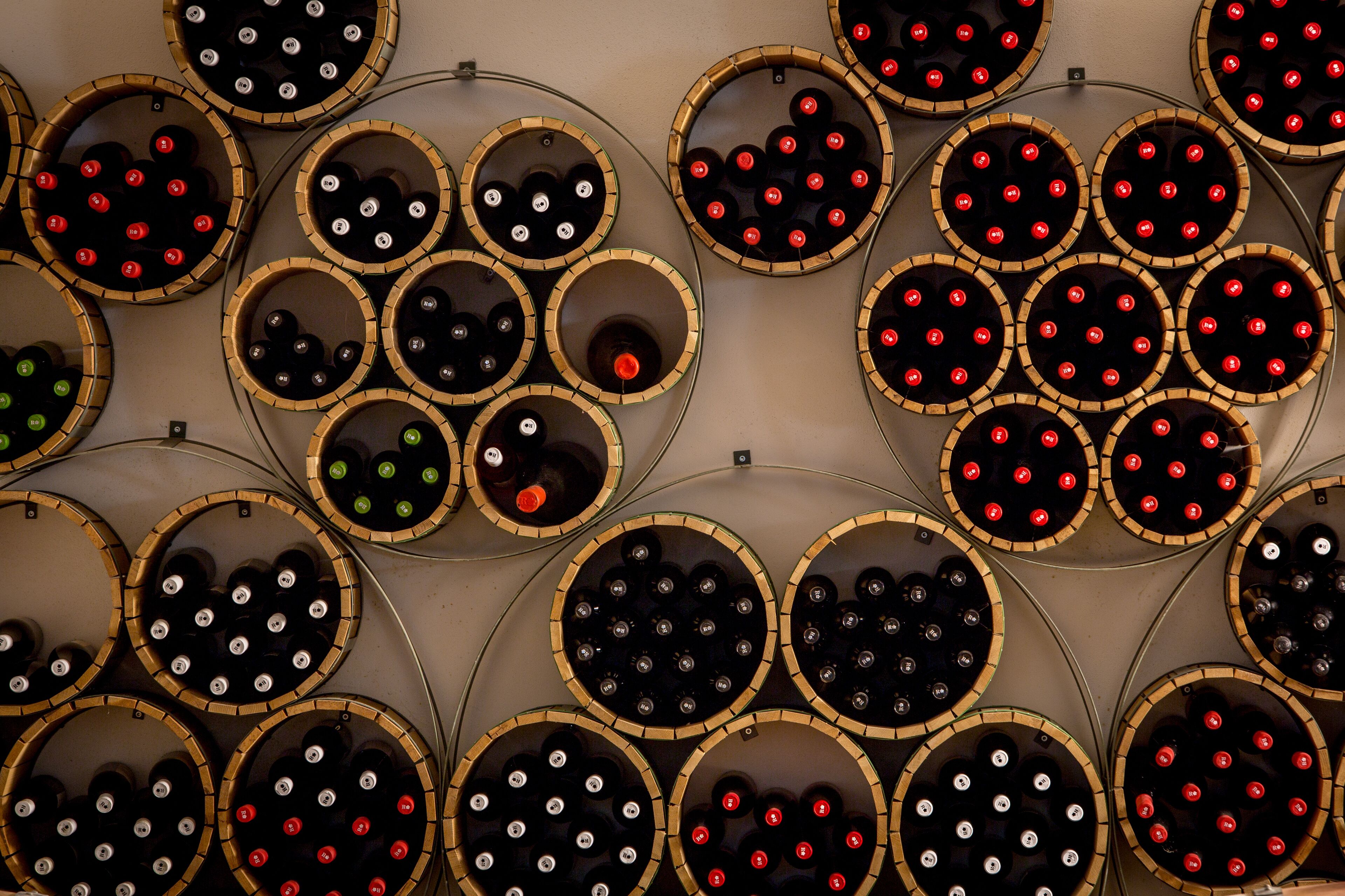 Un mur composé d’étagères circulaires où sont rangées des bouteilles de vin.