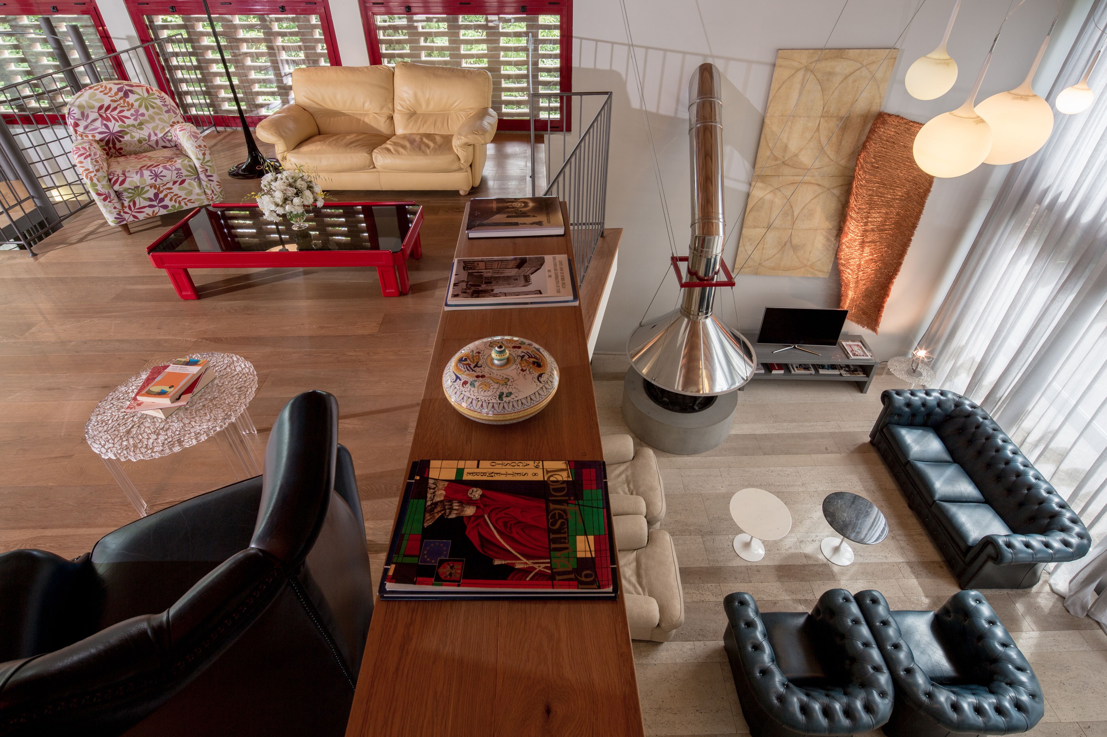A modern living room with a sofa, armchairs, a coffee table, and a fireplace.