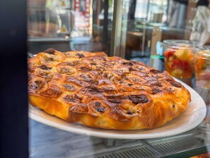 A large, round, golden-brown baked dish with a patterned surface, displayed on a white plate. - ibis Martigues (Martigues)