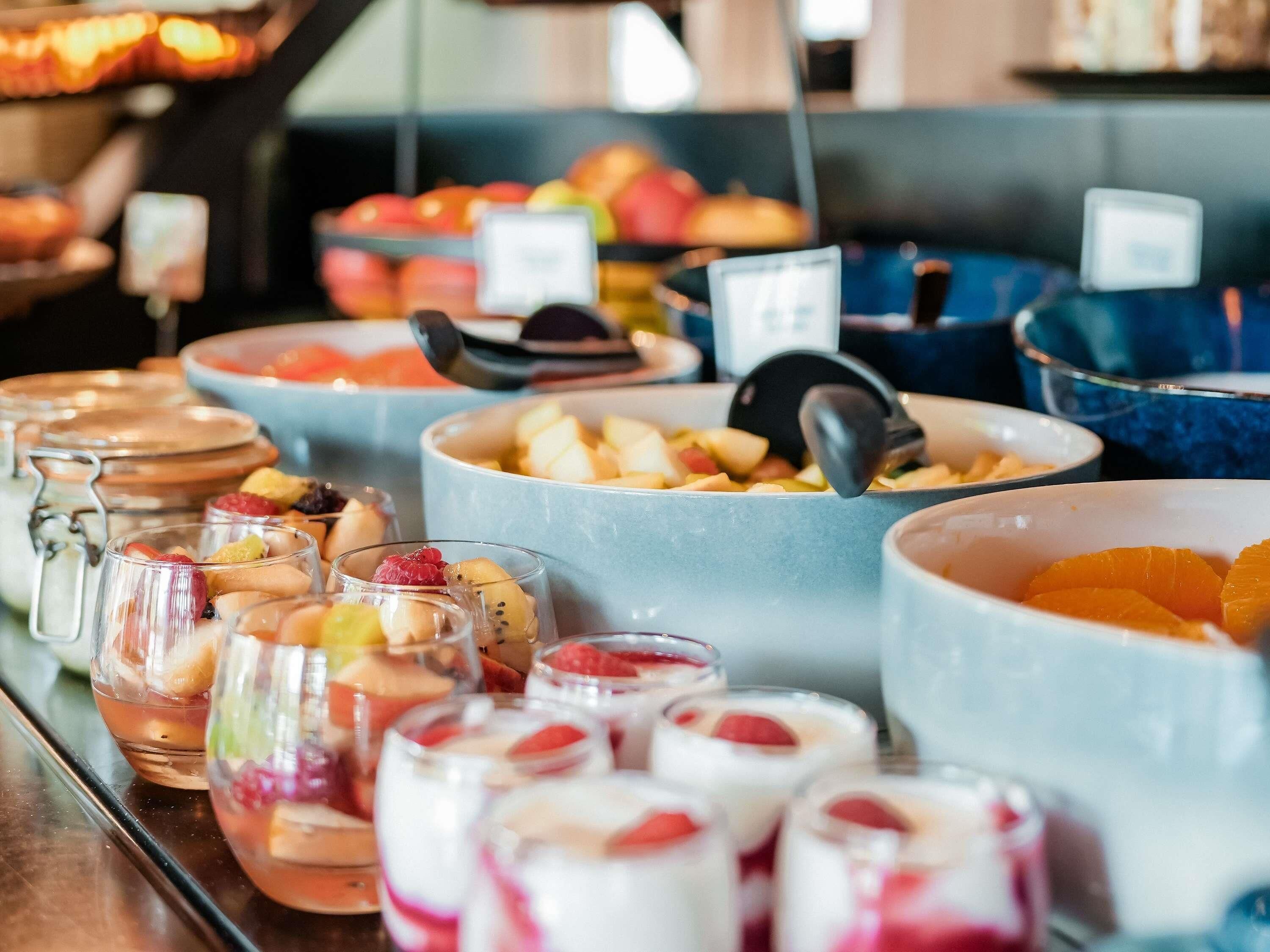 A buffet with various food items and a coffee machine.