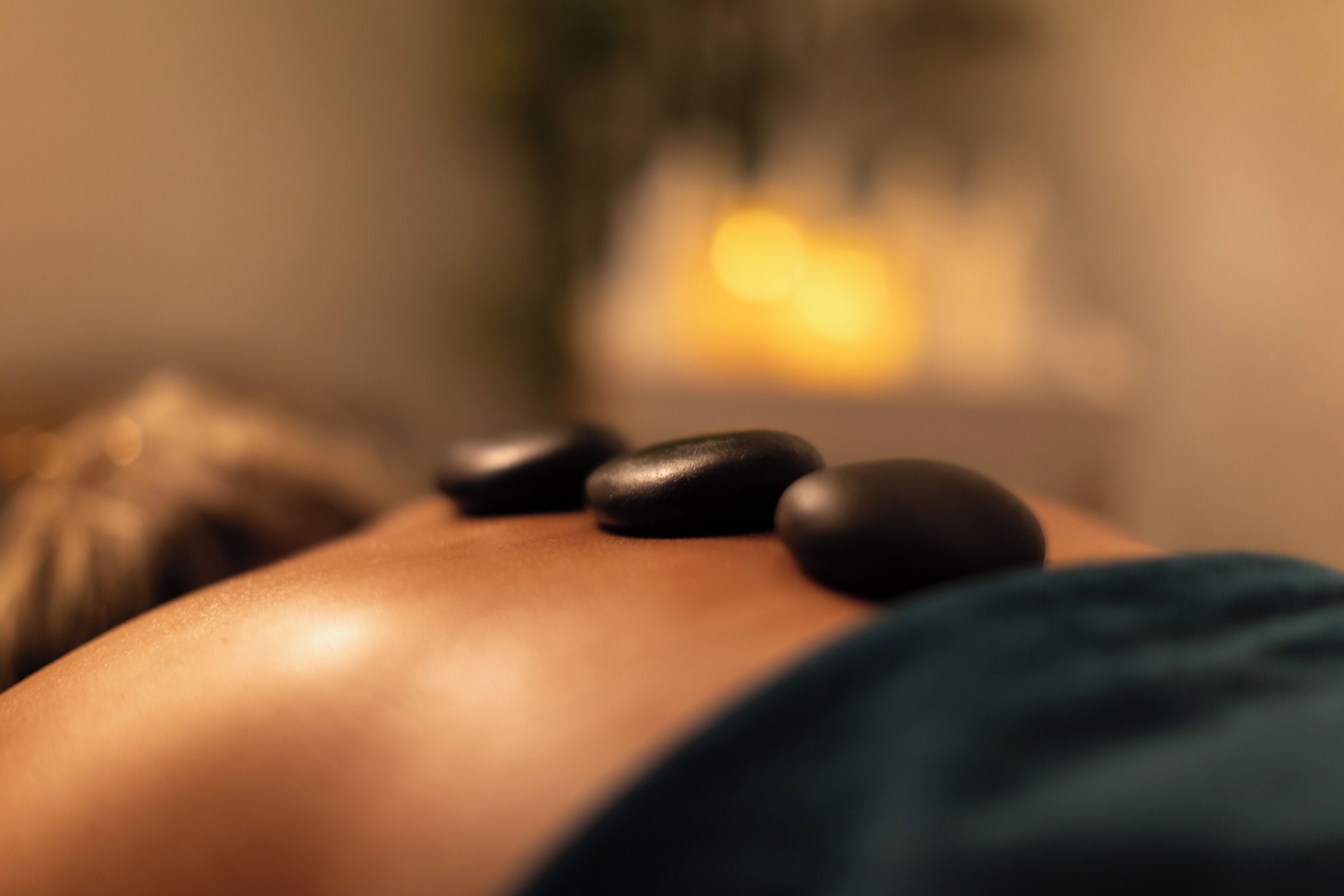 Gros plan d’une pierre de massage posée sur le dos d’une personne.