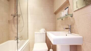 A modern bathroom with a bathtub, toilet, and sink.