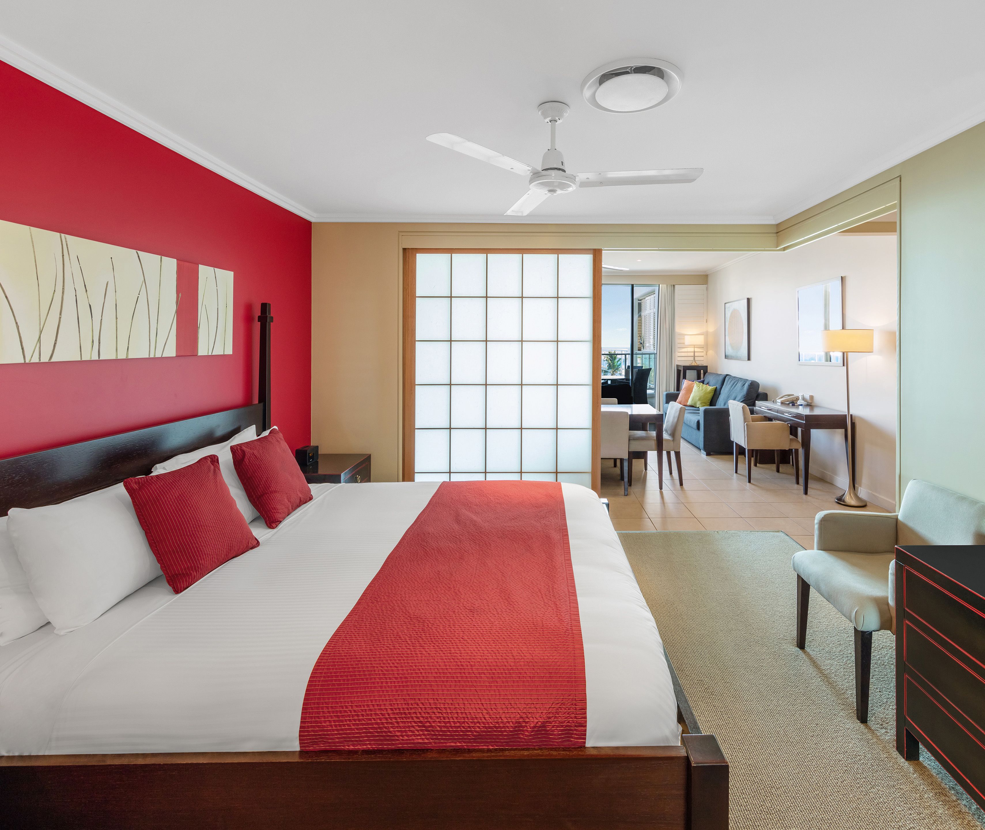 A hotel room with a large bed, a desk, and a chair.
