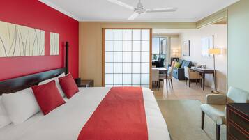 A hotel room with a large bed, a desk, and a chair.