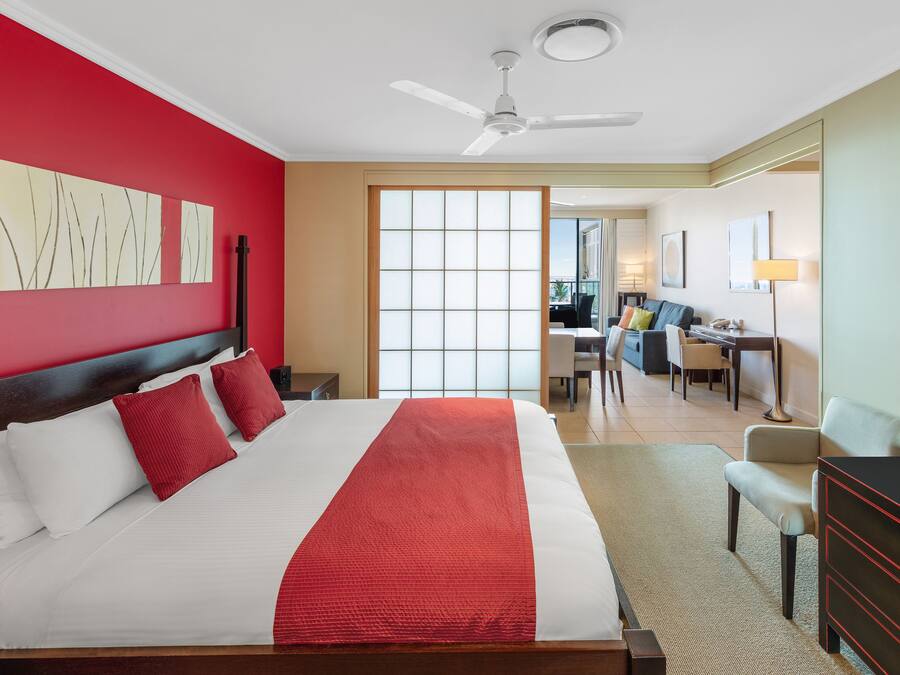 A hotel room with a large bed, a desk, and a chair.