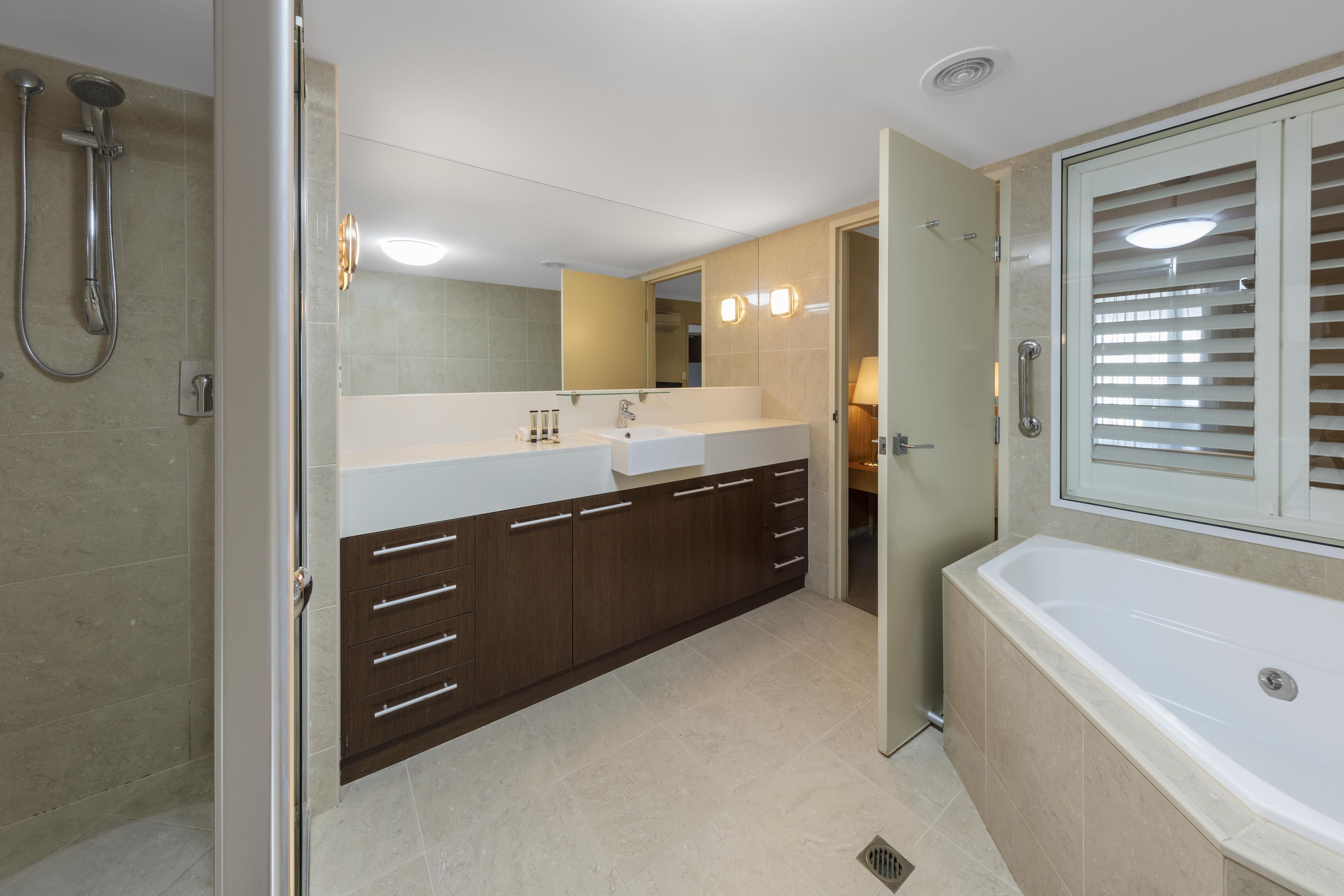 A modern bathroom with a walk-in shower, a double sink vanity, and a standalone bathtub.