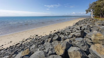 Enjoy a serene beach experience with a scenic pier stretching into the calm waters.