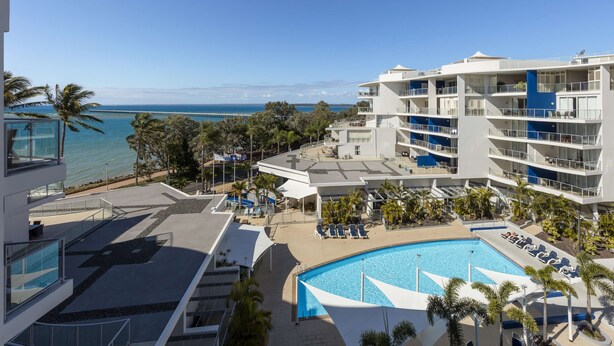 Un hôtel moderne doté d’une piscine, d’un espace extérieur aménagé et offrant une vue sur l’océan.