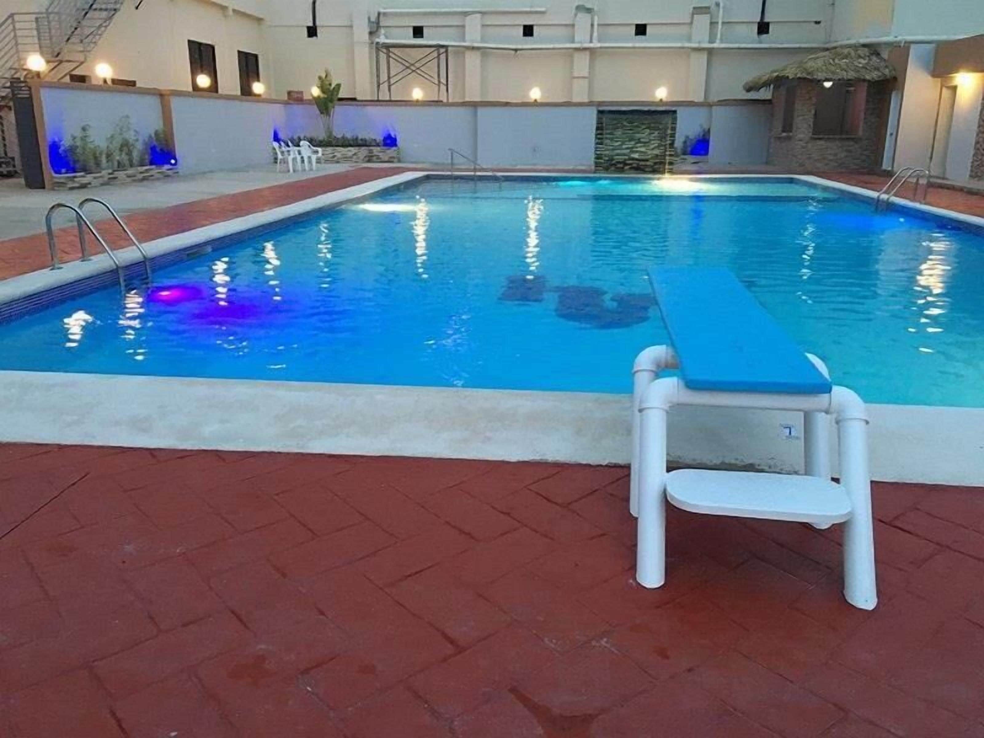 Une piscine avec une chaise bleue et une échelle.