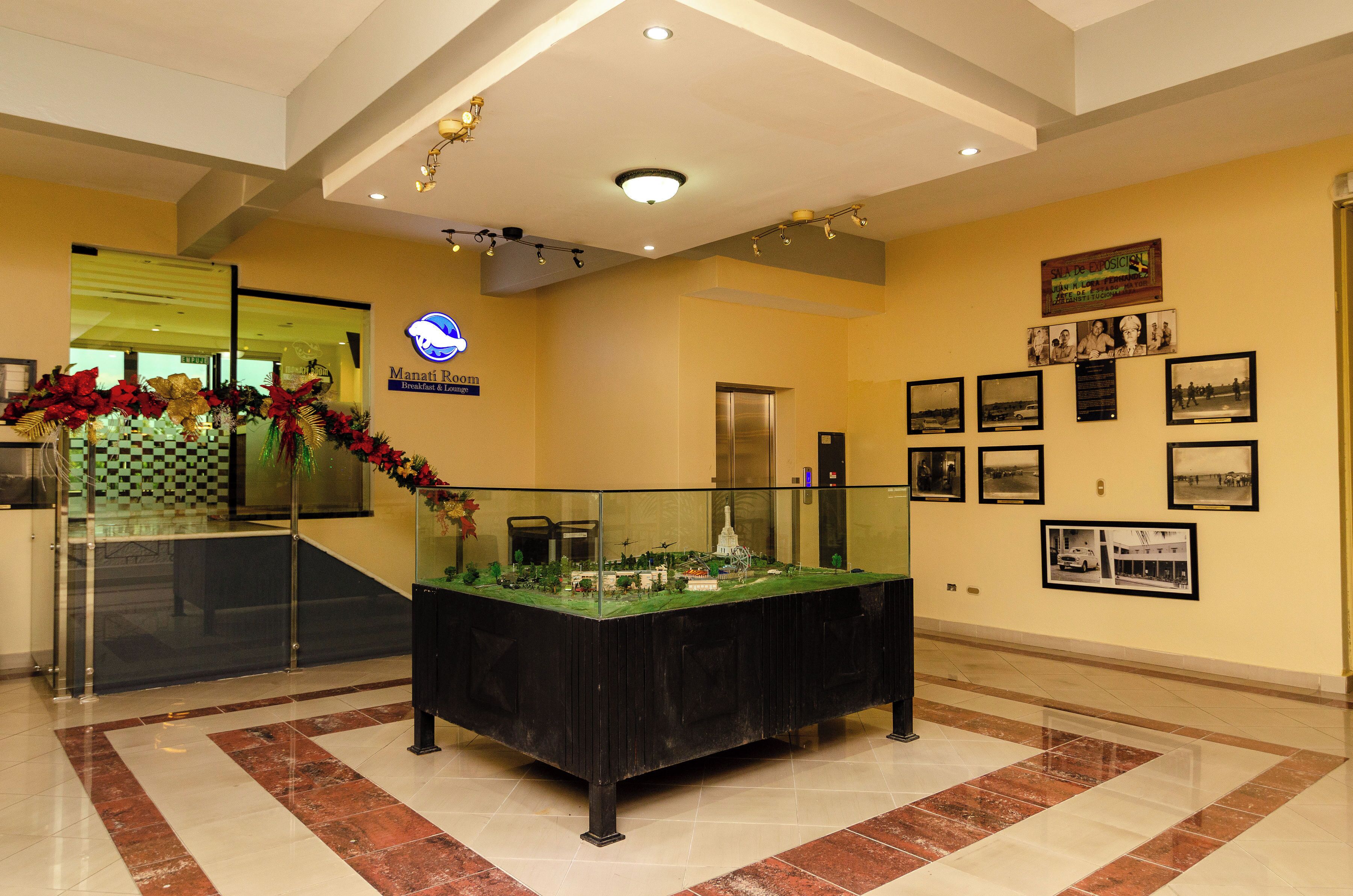 A lobby with a reception desk, a model display, and framed pictures on the wall.