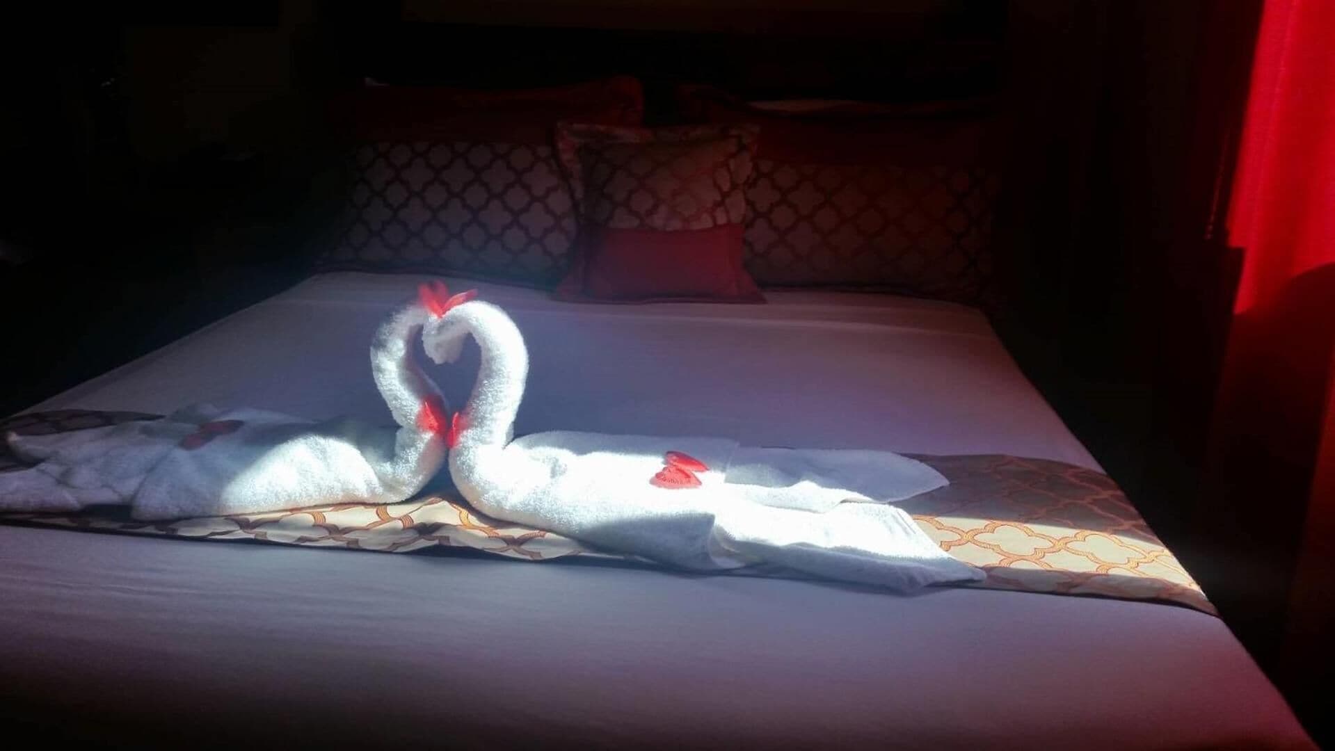 A bed with a decorative swan towel arrangement.