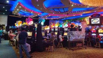 A casino with slot machines, colorful decorations, and a chandelier.
