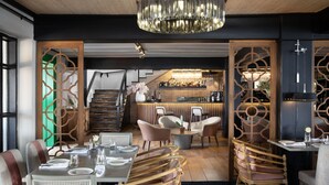 A restaurant with wooden furniture, a bar area, and a chandelier. - Camp David Ranch (Santiago de los Caballeros)