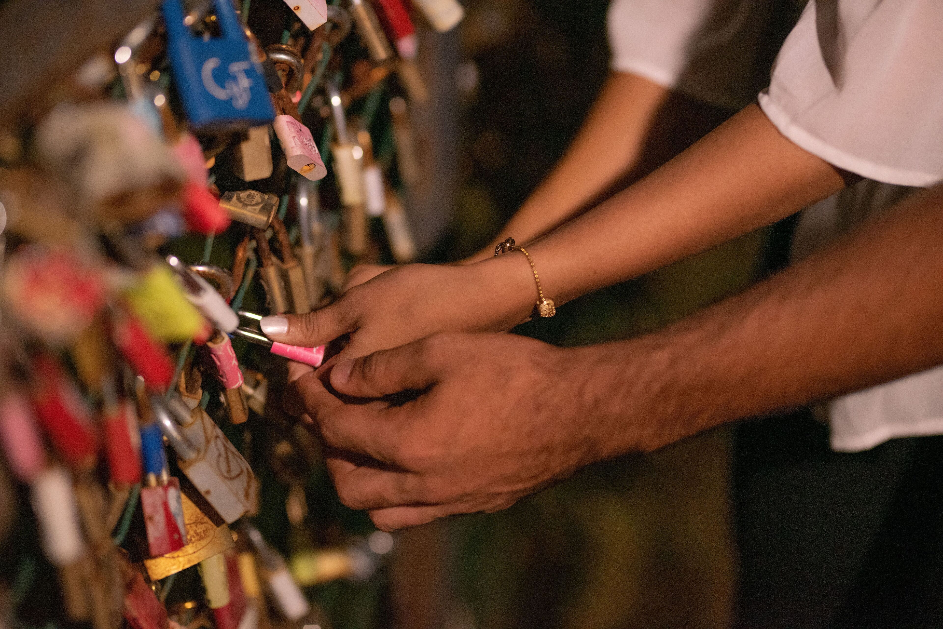 A person unlocking a padlock on a metal structure.