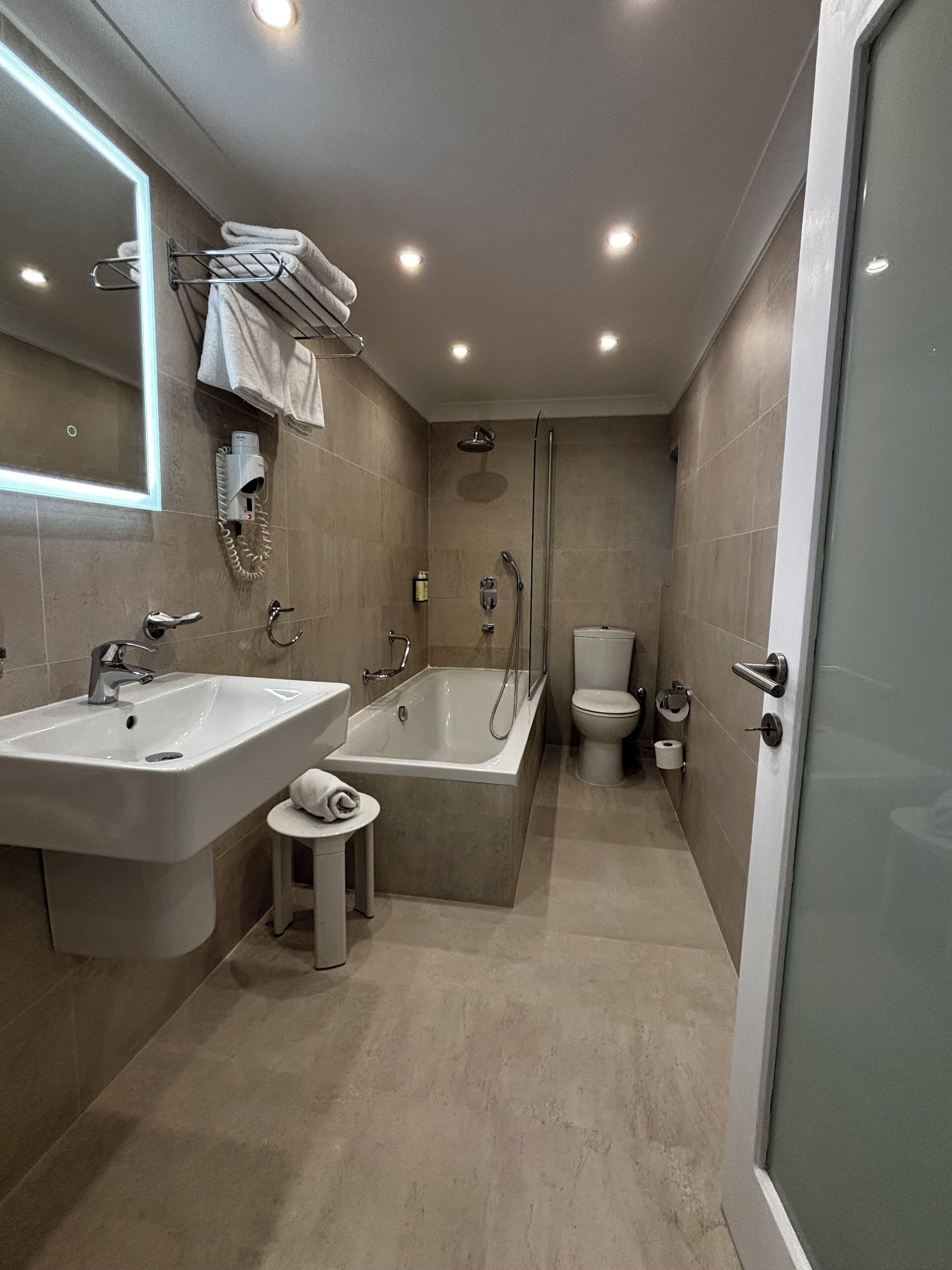 A modern bathroom with a large bathtub, two sinks, a toilet, and a shower.