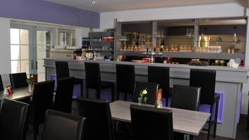 Ein Restaurant mit Barbereich, mehreren Tischen und Stühlen.
