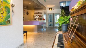 Ein modernes Interieur mit einem Klavier, einer Karte an der Wand und einer Küchenzeile.