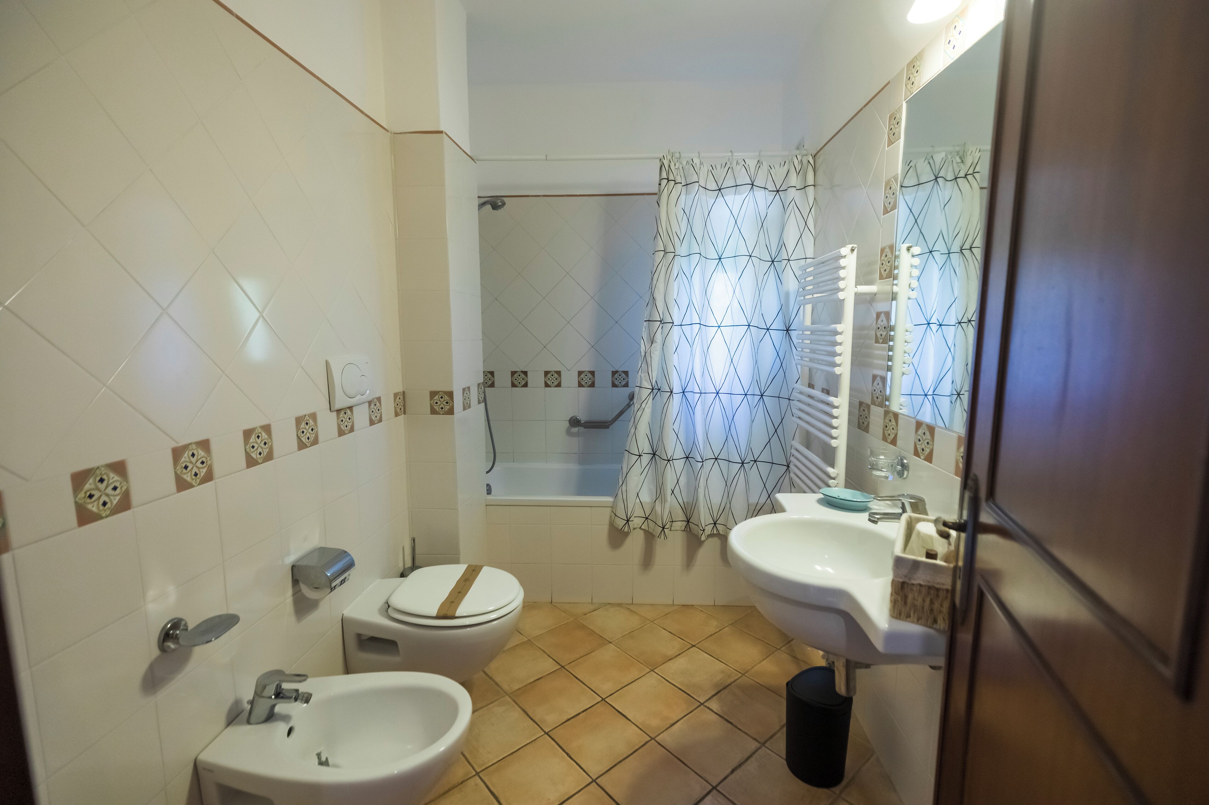 Un baño con ducha, inodoro, lavabo y espejo.