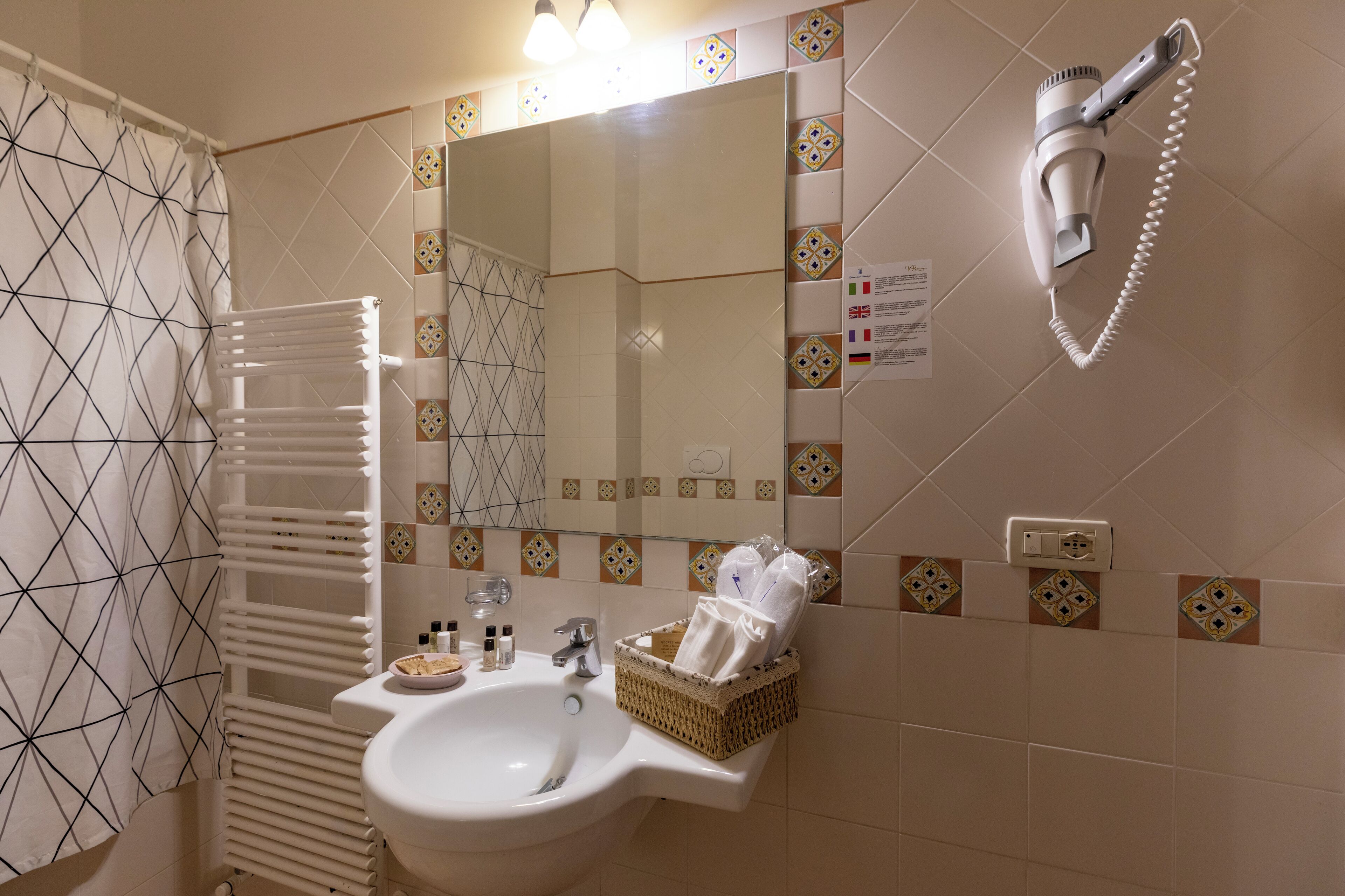 A bathroom with a sink, mirror, towel rack, and hairdryer.