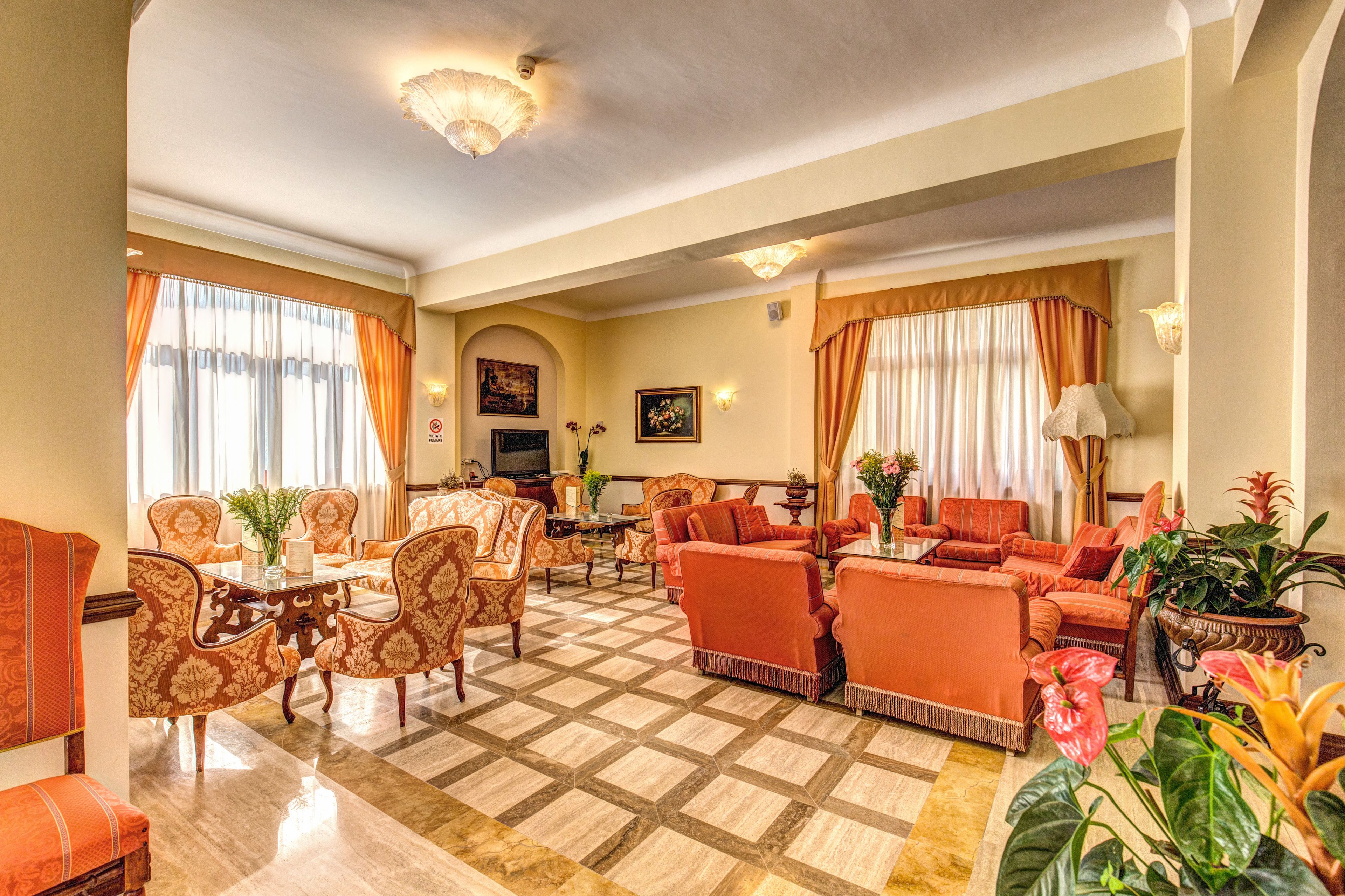 A spacious living area with a checkered floor, a television, and seating arrangements.