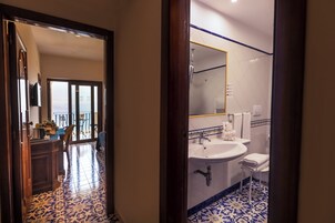 A hotel bathroom with a sink, toilet, and shower.