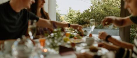 Una mesa de comedor con platos, vasos y un florero.